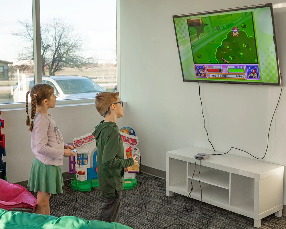 Jude and his friend Hannah playing a Kirby video game at the Superhero Center for Autism